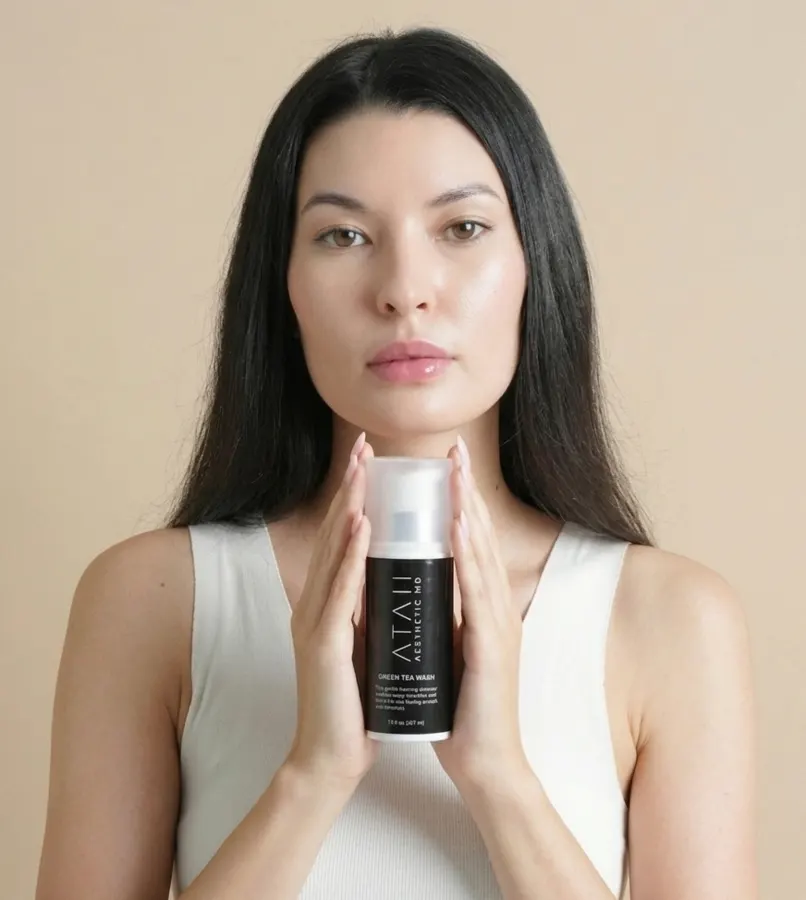 Woman holding Ataii Green Tea Wash bottle, showcasing the daily cleansing ritual